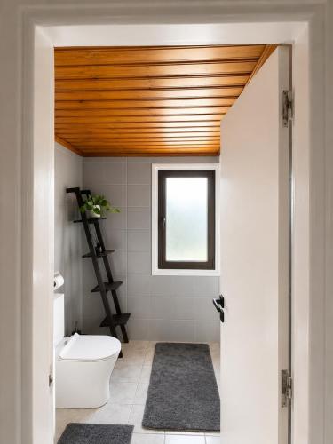 a bathroom with a white toilet and a window at Jasmine House Egkomi in İncirli