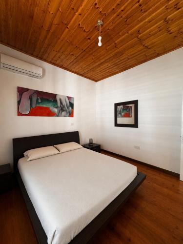 a bedroom with a large bed with a wooden ceiling at Jasmine House Egkomi in İncirli