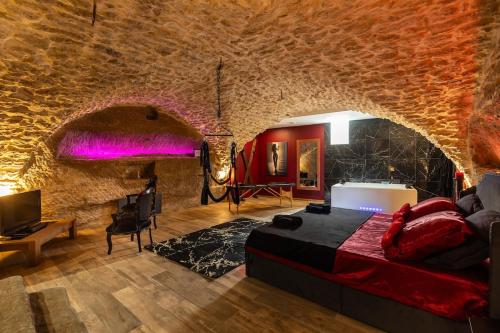 a bedroom with a bed and a stone wall at l'Envoûtée, suite de charme in Sérignan-du-Comtat