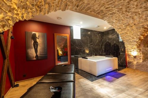 a bathroom with a bath tub in a stone wall at l'Envoûtée, suite de charme in Sérignan-du-Comtat