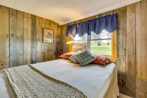 a bedroom with wooden walls and a bed with pillows at Sunset Views & Deck: Lake Champlain Cottage! in Swanton