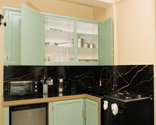 a kitchen with green cabinets and a microwave at Middleham Forest Nook in Roseau