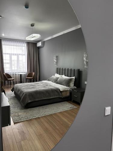 a bedroom with a large bed and a living room at Verde Hotel in Semey