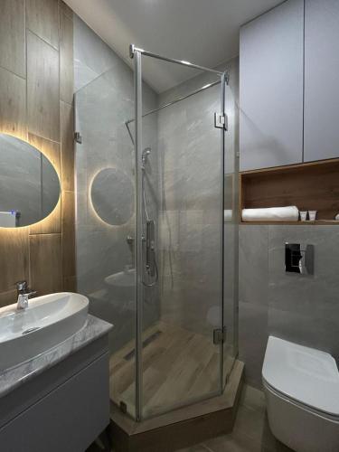 a bathroom with a shower and a toilet and a sink at Verde Hotel in Semey