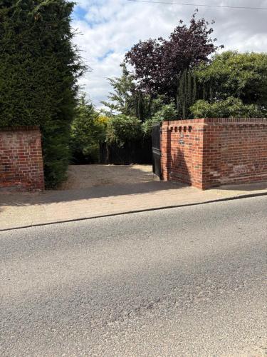 a brick wall on the side of a road at River Garden View in Beccles