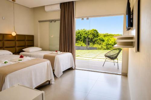 a hotel room with two beds and a balcony at Pousada com piscina, jacuzzi e com vista em Capitólio - Casa Decore in Capitólio