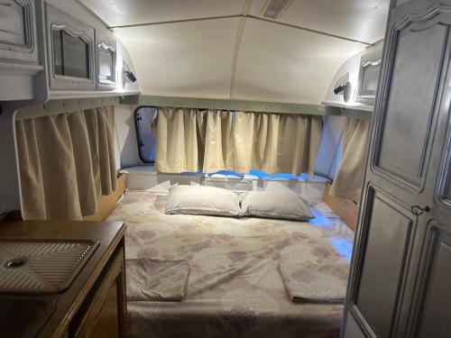 a small room with a bed in the back of an rv at Каравана Summer time in Chernomorets