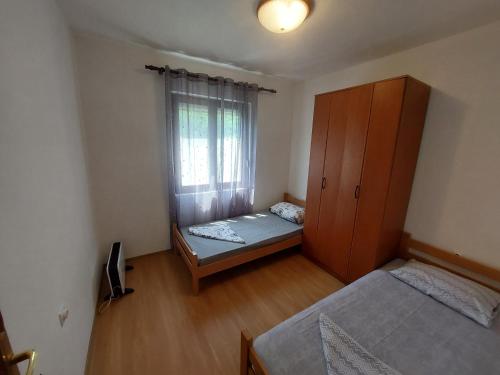 a small bedroom with two beds and a window at PEKOVIĆ in Bar