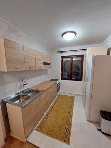 a small kitchen with a sink and a refrigerator at PEKOVIĆ in Bar