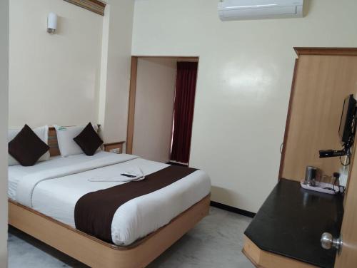 a bedroom with a large bed with a brown and white blanket at Hotel ESS Paradise in Coimbatore