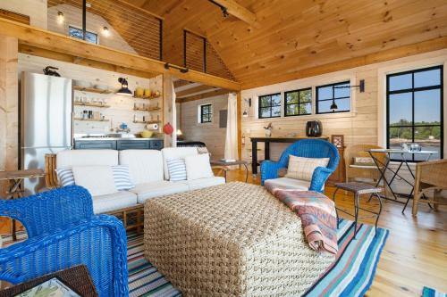 a living room with white furniture and a kitchen at Aril Cottage-Waterfront Escape with Ocean Views in Gouldsboro