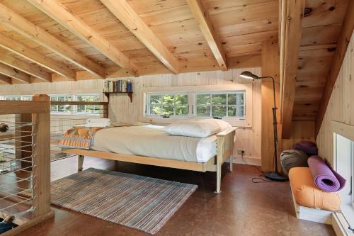 a bedroom with a bed in a room with wooden ceilings at The Boathouse in Brighams Cove
