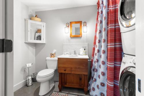 a bathroom with a toilet and a sink and a washing machine at The Boathouse in Brighams Cove