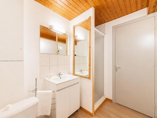 a white bathroom with a sink and a mirror at Le Condrieu in Vérin