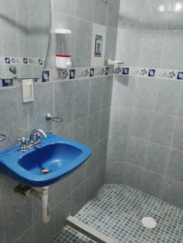 a bathroom with a blue sink and a shower at Hospedaje La Cienega in Zacatlán