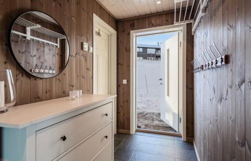 a bathroom with a counter and a mirror and a door at Bualie leilighet in Gol