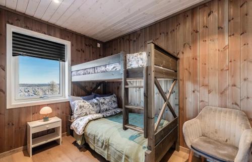 a bedroom with a bunk bed and a chair at Bualie leilighet in Gol
