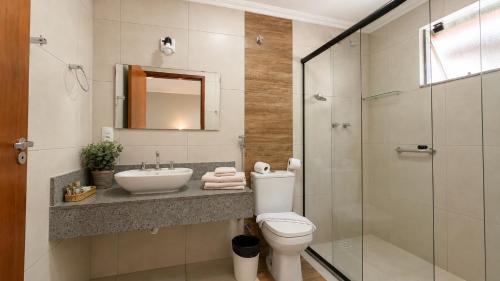 a bathroom with a toilet and a sink and a shower at Vila Francesa Hotel in Penedo