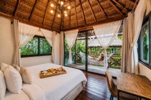 a bedroom with a bed with a tray of fruit on it at Olivia Oceanfront Tulum in Tulum