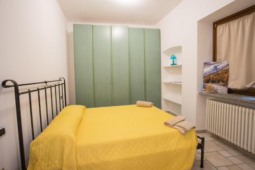 a bedroom with a yellow bed and a green cabinet at Da ME in Aosta