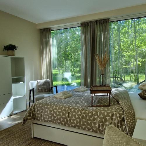 a bedroom with a bed and a large window at Poilsio nameliai TekaTeka in Anykščiai