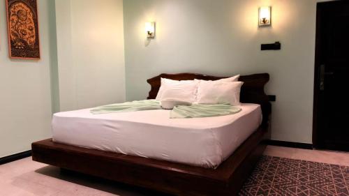 a bed with white sheets and pillows in a room at Abbi Holiday - Jaffna Hotel in Jaffna