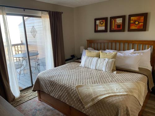 a bedroom with a bed with pillows and a balcony at little mountain haven in Mount Torry Furnace