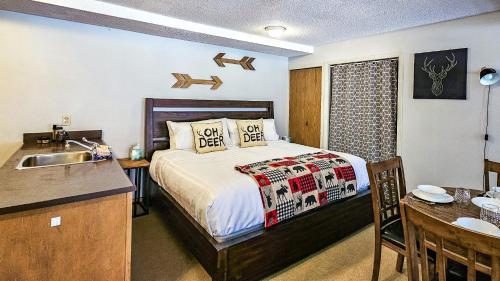 a bedroom with a bed and a kitchen with a sink at Horsethief Lodge by StayIn in Panorama