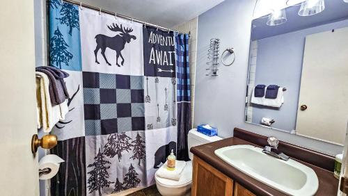 a bathroom with a deer shower curtain and a sink at Horsethief Lodge by StayIn in Panorama
