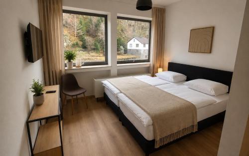a bedroom with a large bed and a window at Äuchen am Rosenthal in Monschau