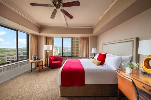 a hotel room with a large bed and a desk at The Hotel Captain Cook in Anchorage