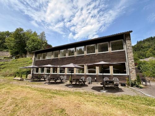 a building with tables and umbrellas in front of it at Äuchen am Rosenthal in Monschau