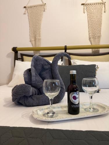 a bottle of wine and two glasses on a bed at Kokkala Guestrooms in Kokkala
