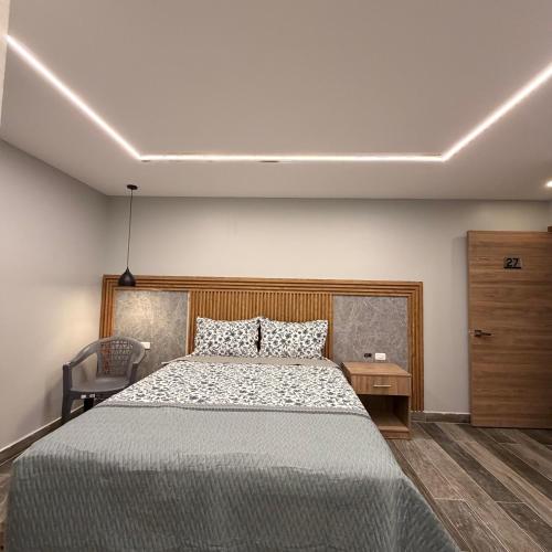 a bedroom with a bed and a dresser at Hotel Ulloa Inn in Quito