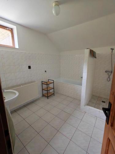 a white bathroom with a tub and a sink at Kordíky in Kordíky