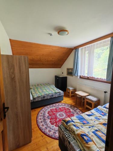 a bedroom with two beds and a rug at Kordíky in Kordíky