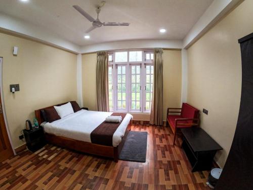 a bedroom with a bed and a large window at Taleries Stays in Dirang Dzong