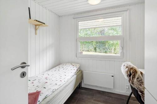 a small bedroom with a bed and a window at LF16127-Logstor-Amandasvej-27 in Trend