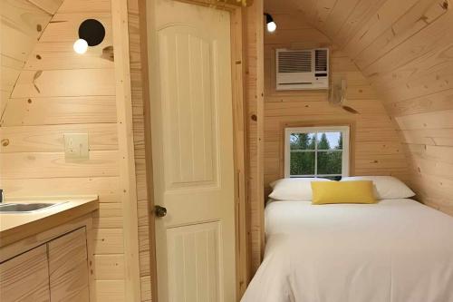 a small bedroom with a bed in a tiny house at Sun Outdoors Yellowstone North in Gardiner