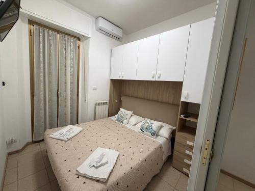 a small bedroom with a bed and white cabinets at La casa di Nicole in Pero
