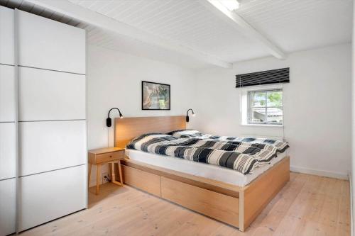 a bedroom with a bed and a desk and a window at 3309-Stege-Holmemosevej-9 in Stege