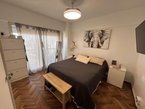 a bedroom with a bed and a picture of an elephant at my depto in Vicente López