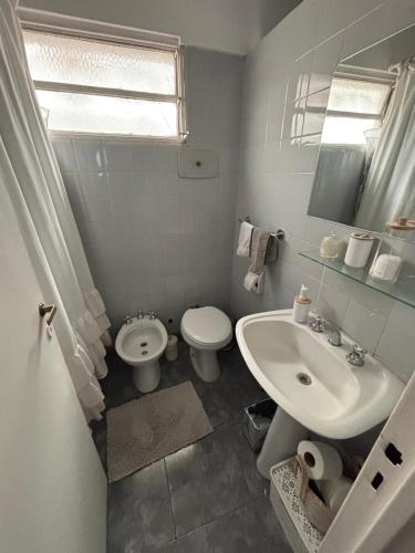 a white bathroom with a sink and a toilet at my depto in Vicente López