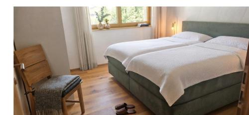 a bedroom with a large bed and a window at Moderne Ferienwohnung im Bregenzerwald in Au im Bregenzerwald