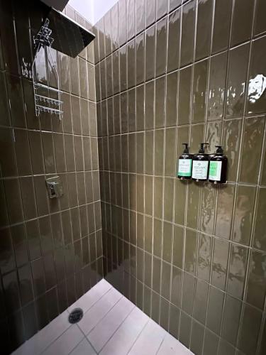 a bathroom with a shower with three bottles on the wall at Tradere in Guadalajara
