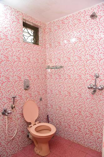 a bathroom with a toilet and a shower at Jes Guest House in Majorda