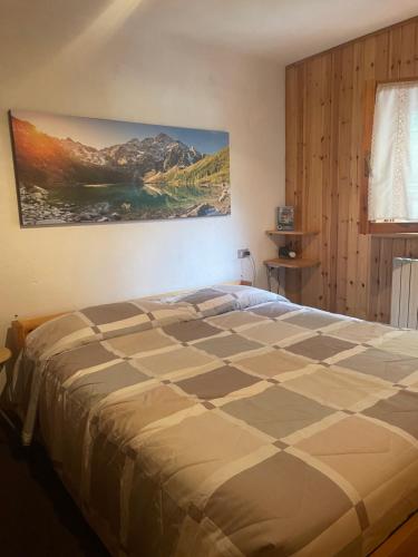 a bedroom with a bed with a painting on the wall at Il Rifugio di Marcella in Challand Saint Anselme