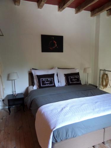 a bedroom with a bed with two pillows on it at Domaine Pouzoult, gîte l'Escalier in Sazeray