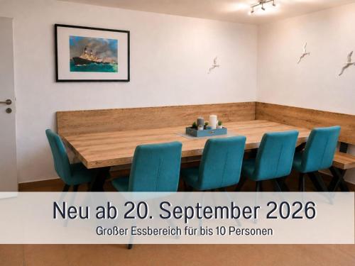 a conference room with a wooden table and blue chairs at Robbenglück Tossens - Ruhe, Garten und Nordseegefühl in Tossens