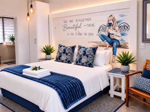a bedroom with a large bed with a poster on the wall at Forget me not Selfcatering Apartments in Nelspruit